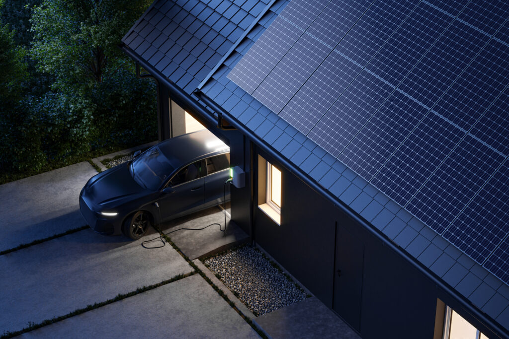 A high-angle night view of a sustainable home with solar panels and a parked EV for powershare-model-3-model-y blog.